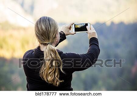 Stock Photo - "Caucasian woman photographing Yosemite National Park, California, United States". Fotosearch