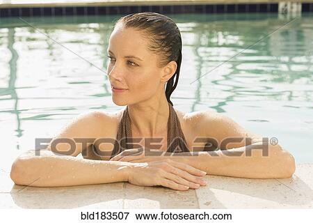Stock Photo - Caucasian woman poolside in swimming pool. Fotosearch