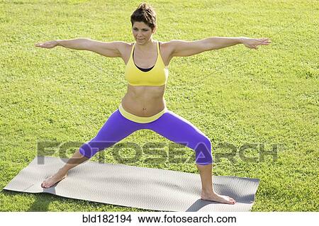 Picture - Caucasian woman practicing yoga outdoors. Fotosearch