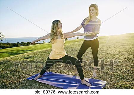 Caucasian woman practicing yoga with trainer in field View Large Photo Image Stock Photograph - Caucasian woman practicing yoga with trainer in field. Fotosearch