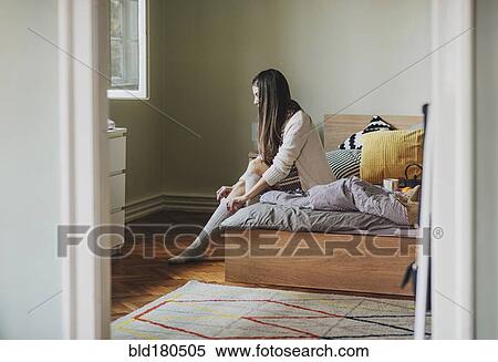 Caucasian woman pulling up sock on bed View Large Photo Image Stock Photography - Caucasian woman pulling up sock on bed. Fotosearch