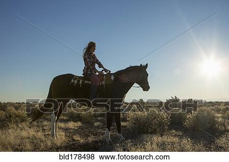 Caucasian woman riding horse in field View Large Photo Image Stock Photo - Caucasian woman riding horse in field. Fotosearch