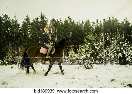 Caucasian woman riding horse on snowy path View Large Photo Image Stock Photo - Caucasian woman riding horse on snowy path. Fotosearch