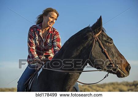 Stock Photo - Caucasian woman riding horse. Fotosearch