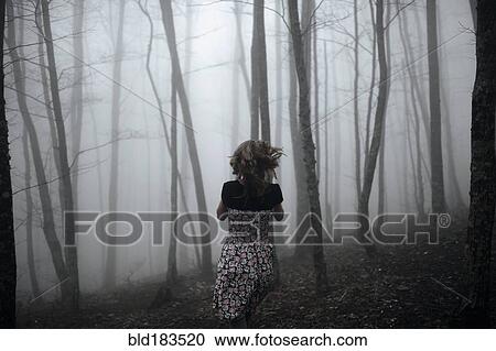 Stock Image - Caucasian woman running in forest. Fotosearch