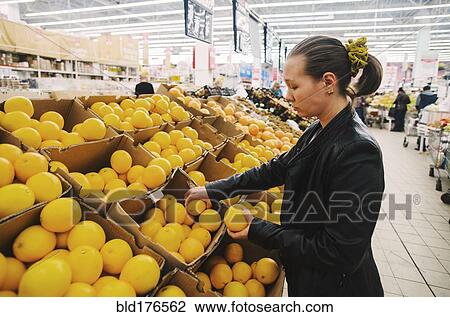 Stock Image - Caucasian woman shopping in grocery store. Fotosearch