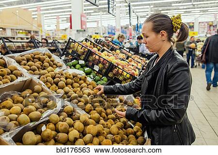 Stock Image - Caucasian woman shopping in grocery store. Fotosearch