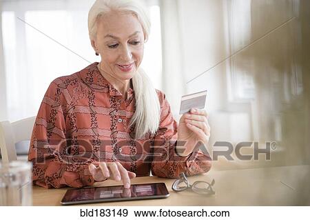 Stock Photo - Caucasian woman shopping on digital tablet. Fotosearch
