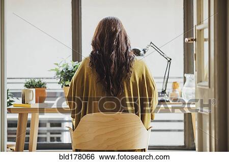 Stock Photograph - Caucasian woman sitting at desk. Fotosearch