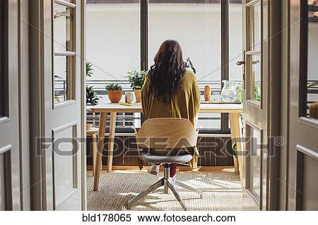 Caucasian woman sitting at desk View Large Photo Image Stock Photography - Caucasian woman sitting at desk. Fotosearch