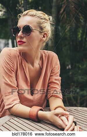 Stock Photograph - Caucasian woman sitting at table. Fotosearch