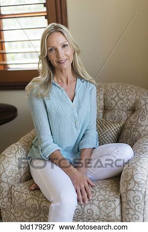 Stock Photo - Caucasian woman sitting in armchair. Fotosearch