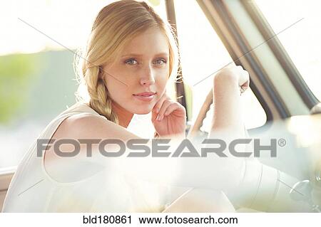 Stock Image - Caucasian woman sitting in car. Fotosearch