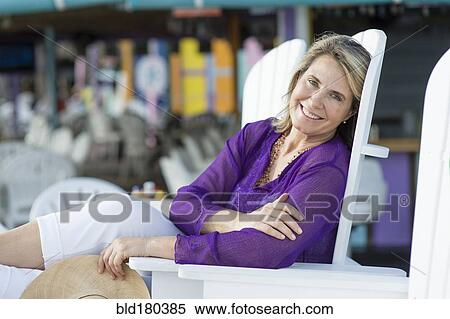 Stock Photography - Caucasian woman sitting in lawn chair. Fotosearch