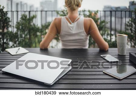 Caucasian woman sitting on balcony View Large Photo Image Stock Photo - Caucasian woman sitting on balcony. Fotosearch