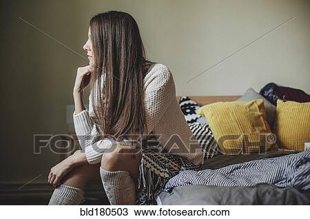 Caucasian woman sitting on bed View Large Photo Image Stock Image - Caucasian woman sitting on bed. Fotosearch