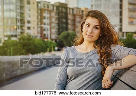 Stock Photo - Caucasian woman sitting on bench. Fotosearch
