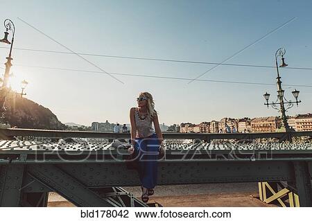 Caucasian woman sitting on bridge View Large Photo Image Stock Image - Caucasian woman sitting on bridge. Fotosearch