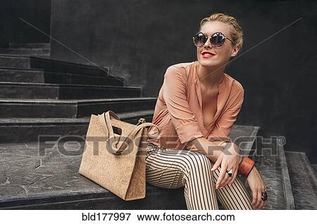 Stock Photo - Caucasian woman sitting on stairs. Fotosearch