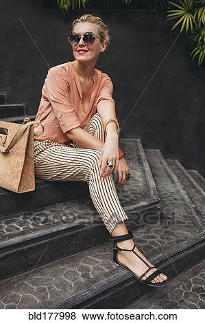 Stock Photo - Caucasian woman sitting on stairs. Fotosearch