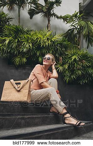 Caucasian woman sitting on stairs View Large Photo Image Stock Photo - Caucasian woman sitting on stairs. Fotosearch