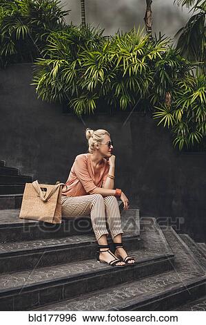 Stock Photograph - Caucasian woman sitting on stairs. Fotosearch