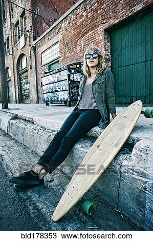 Caucasian woman sitting with skateboard View Large Photo Image Stock Image - Caucasian woman sitting with skateboard. Fotosearch