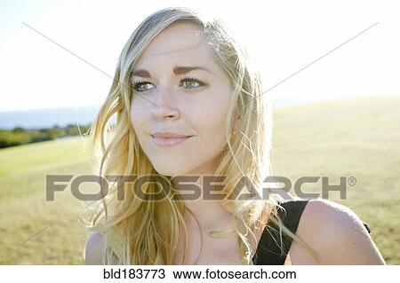 Stock Image - Caucasian woman smiling in field. Fotosearch