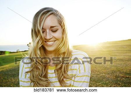 Stock Image - Caucasian woman smiling in field. Fotosearch