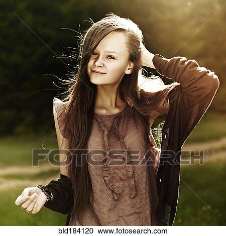 Stock Image - Caucasian woman smiling in field. Fotosearch