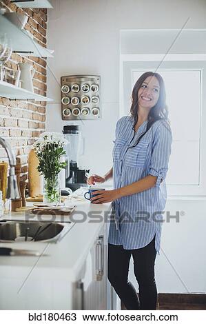 Caucasian woman smiling in kitchen View Large Photo Image Stock Image - Caucasian woman smiling in kitchen. Fotosearch