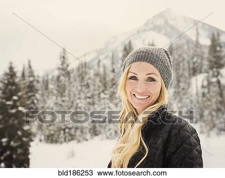 Stock Image - Caucasian woman smiling in snow. Fotosearch