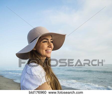 Stock Image - Caucasian woman smiling on beach. Fotosearch
