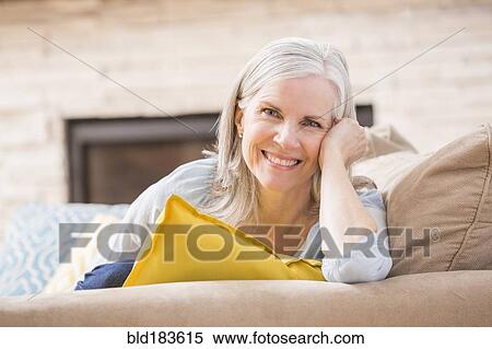 Caucasian woman smiling on sofa View Large Photo Image Stock Photography - Caucasian woman smiling on sofa. Fotosearch