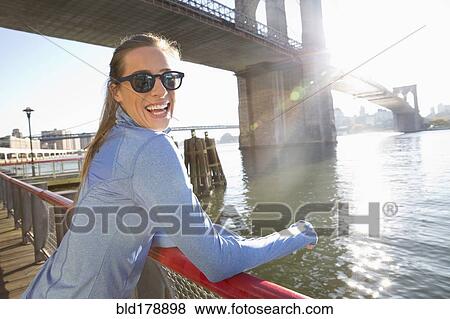 Stock Photo - "Caucasian woman smiling on waterfront, New York, New York, United States". Fotosearch