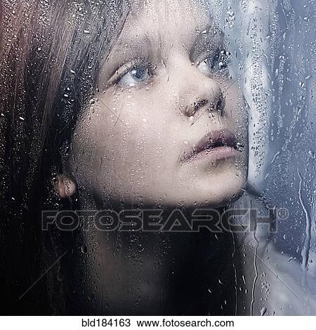 Caucasian woman standing at wet glass View Large Photo Image Stock Image - Caucasian woman standing at wet glass. Fotosearch