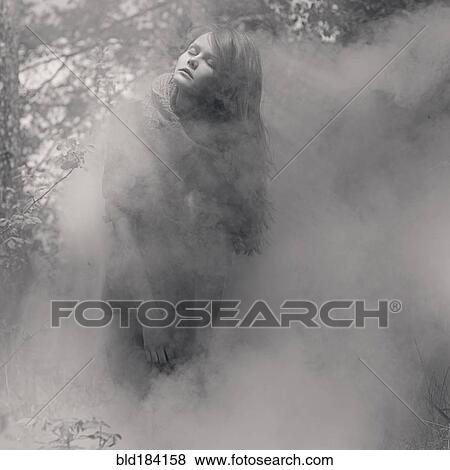 Stock Photo - Caucasian woman standing in mist. Fotosearch