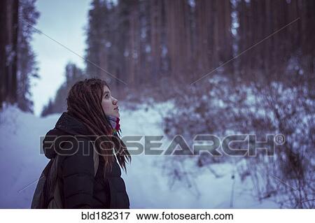 Stock Photo - Caucasian woman standing in snowy forest. Fotosearch