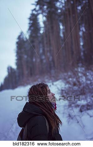 Stock Photograph - Caucasian woman standing in snowy forest. Fotosearch