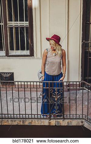 Stock Image - Caucasian woman standing on balcony. Fotosearch