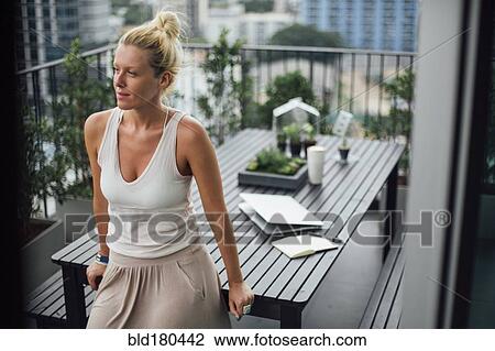Caucasian woman standing on balcony View Large Photo Image Stock Image - Caucasian woman standing on balcony. Fotosearch