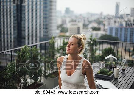Caucasian woman standing on balcony View Large Photo Image Stock Image - Caucasian woman standing on balcony. Fotosearch