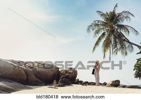 Stock Photo - Caucasian woman standing on beach. Fotosearch