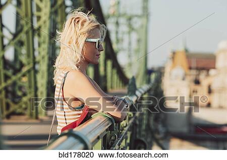 Stock Image - Caucasian woman standing on bridge. Fotosearch