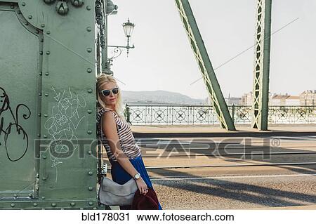 Stock Image - Caucasian woman standing on bridge. Fotosearch