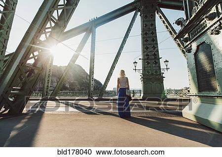 Caucasian woman standing on bridge View Large Photo Image Stock Image - Caucasian woman standing on bridge. Fotosearch