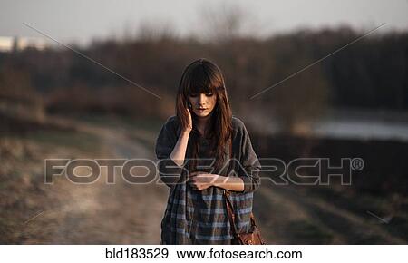 Caucasian woman standing on dirt road View Large Photo Image Stock Photo - Caucasian woman standing on dirt road. Fotosearch