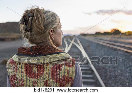 Caucasian woman standing on train tracks View Large Photo Image Stock Image - Caucasian woman standing on train tracks. Fotosearch