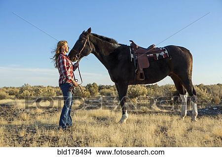 Caucasian woman standing with horse in field View Large Photo Image Picture - Caucasian woman standing with horse in field. Fotosearch