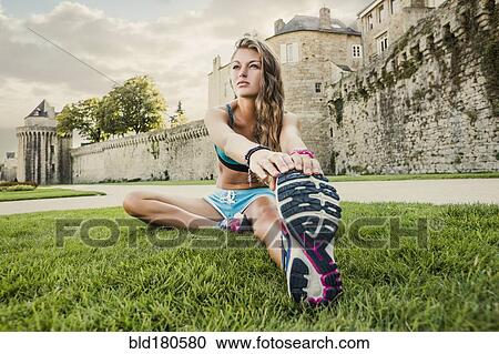 Stock Image - Caucasian woman stretching outdoors. Fotosearch